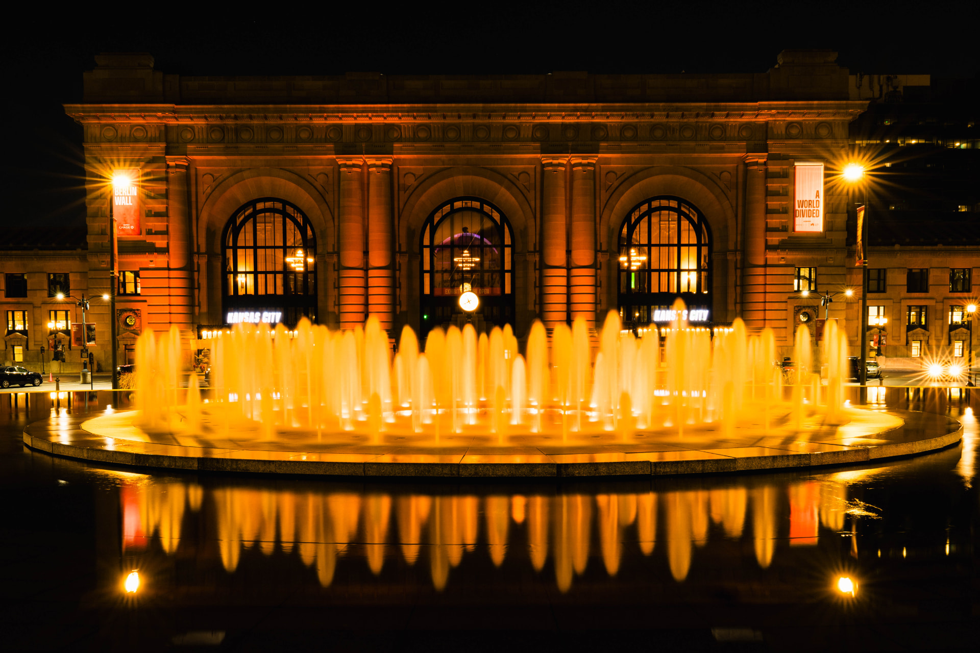 Union Station facade behind a wide golden fountain and its reflection