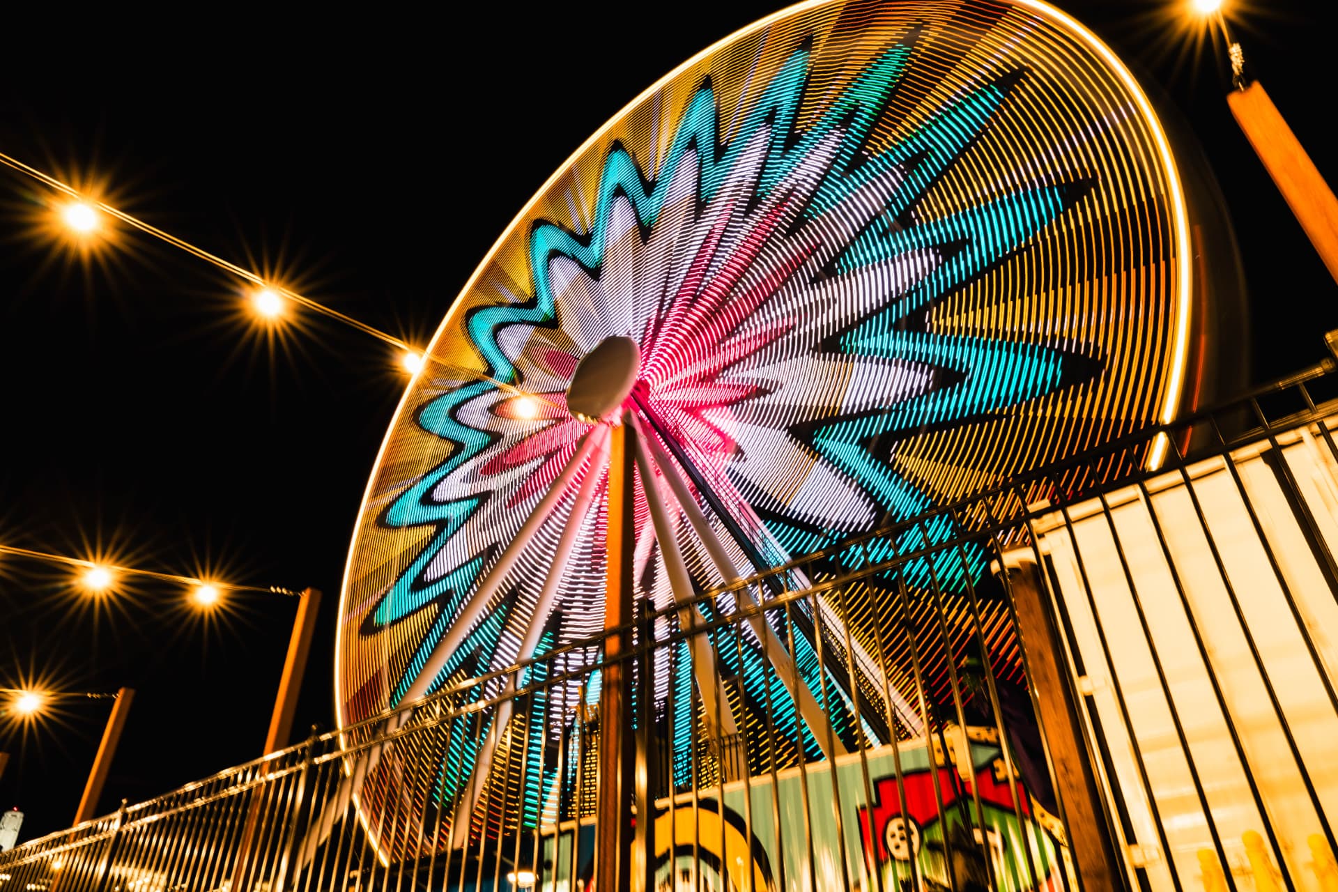 The Midnight Carousel — a Ferris wheel painted with long-exposure light against the night sky